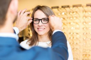 Thomas Turtle Optician customer putting on her new glasses